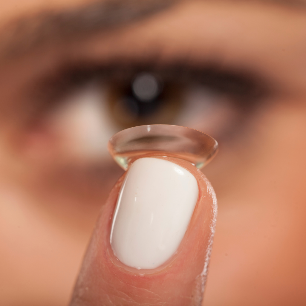 Women with contact lens on the tip of her finger